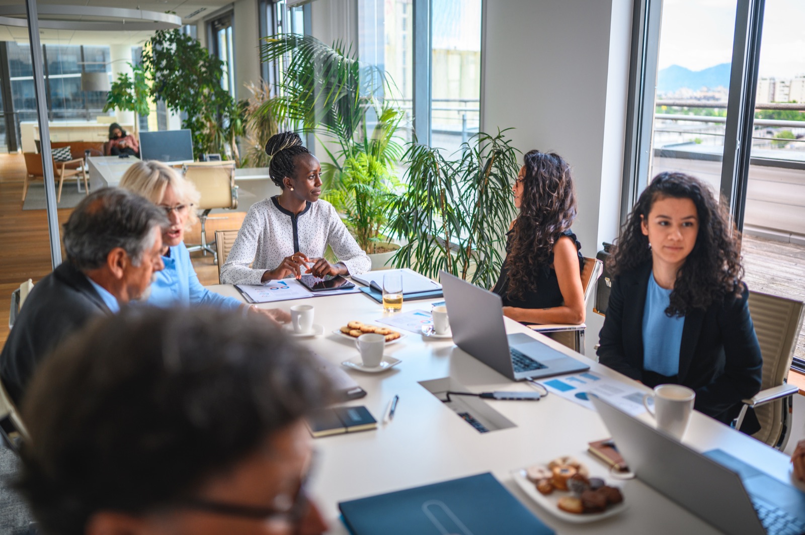 A team in discussion around a conference table in a bright office